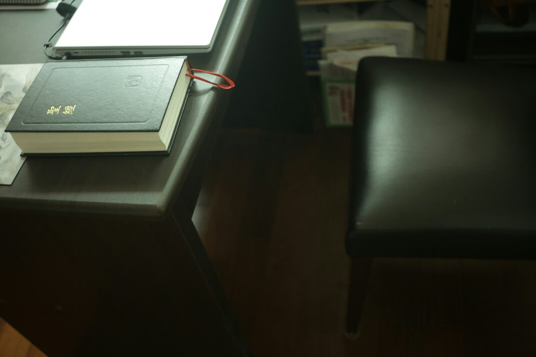 Desk covered with government documents, folders and a magnifying glass